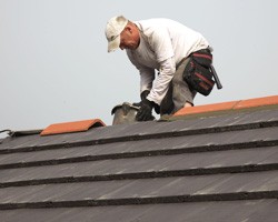 Roofer placing new ridge tiles